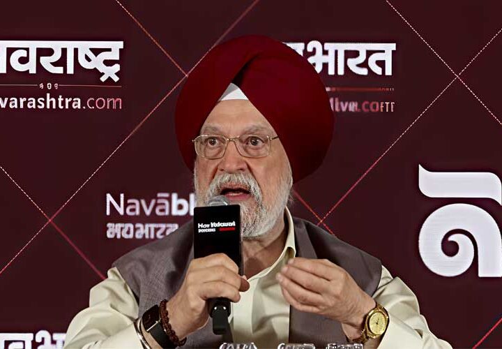 मैरून रंग की पगड़ी, चश्मा और नेहरू जैकेट पहने केंद्रीय मंत्री हरदीप सिंह पुरी हाथ में माइक थामकर बोलते हुए, पृष्ठभूमि में नवराष्ट्र और नवभारत के लोगो वाला मैरून बैकड्रॉप दिखाई दे रहा है।