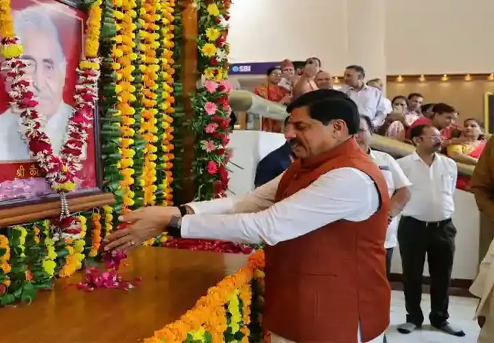 मध्य प्रदेश के मुख्यमंत्री डॉ. मोहन यादव गेंदे के फूलों से सजी पूर्व मुख्यमंत्री स्वर्गीय कैलाश जोशी की तस्वीर पर पुष्पांजलि अर्पित करते हुए, जबकि अन्य नेता पास में खड़े हैं.